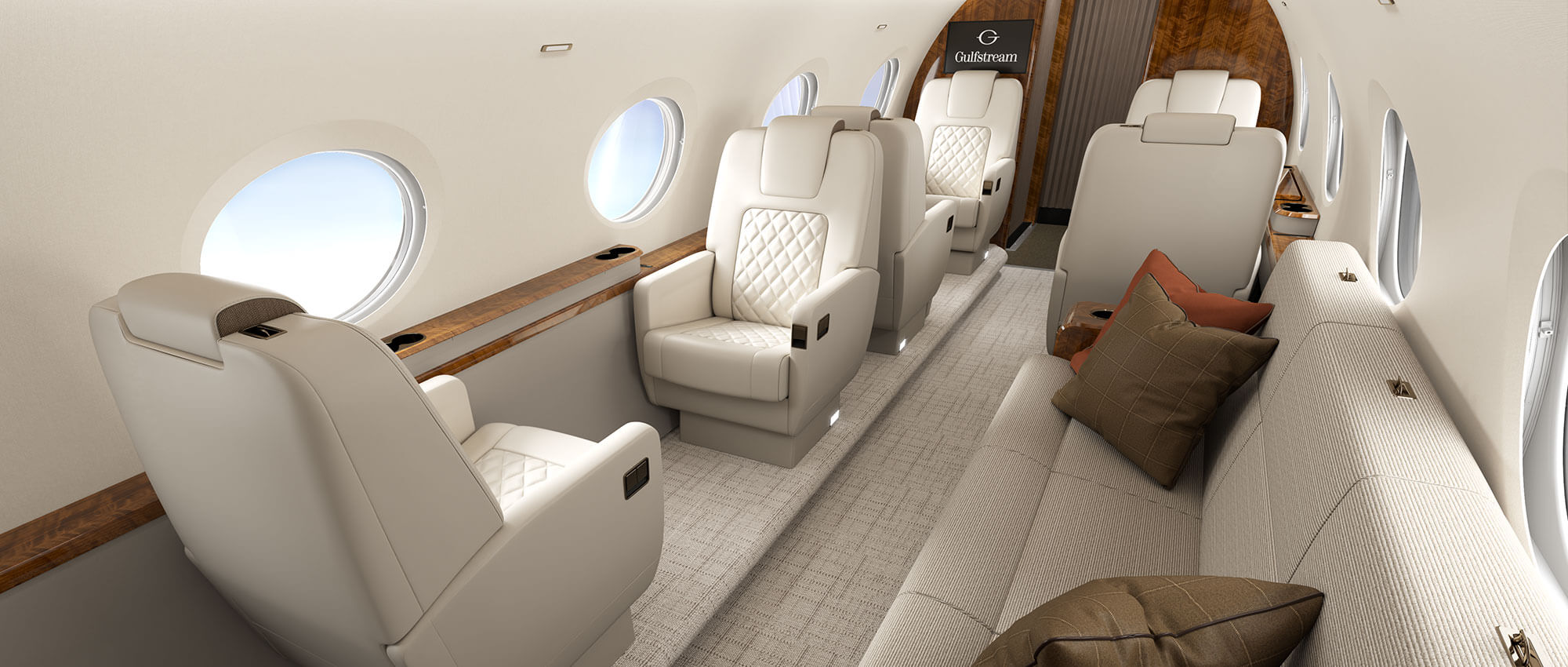 A G300 interior looking forward shows elegant, stitched leather seats and a divan bathed in natural light from iconic Gulfstream Panoramic Oval Windows.