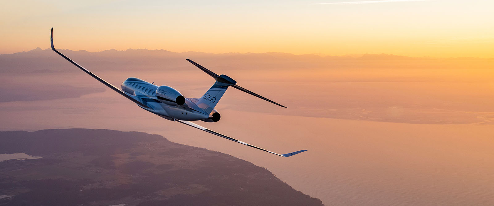 G700 flying over a coastal estuary at sunset
