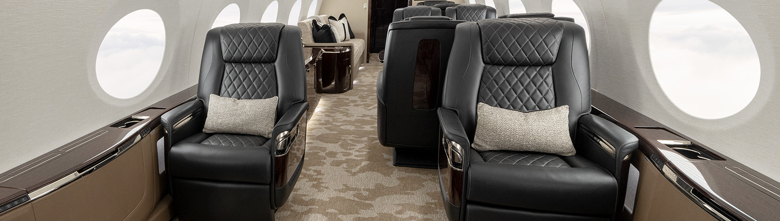 White- and cream-colored cabin, accented with yellow lumbar pillows and black marble tabletops