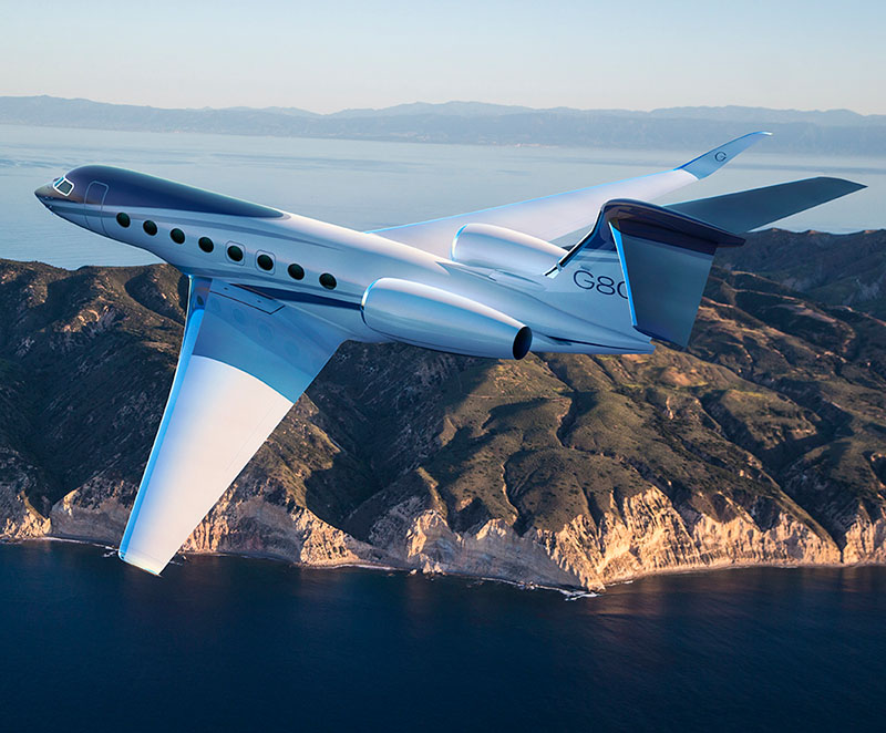 G800 cruises toward a rugged coastline with high cliffs in the foreground and a large bay in the distance