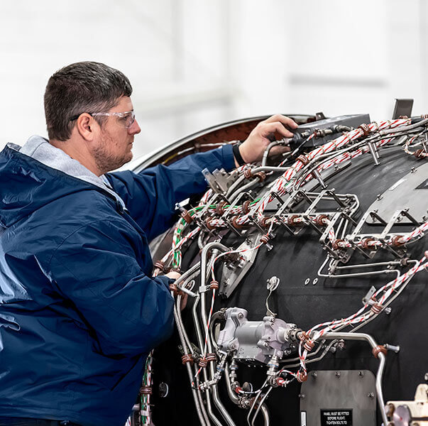 A Gulfstream Customer Support employee services an Auxiliary Power Unit.