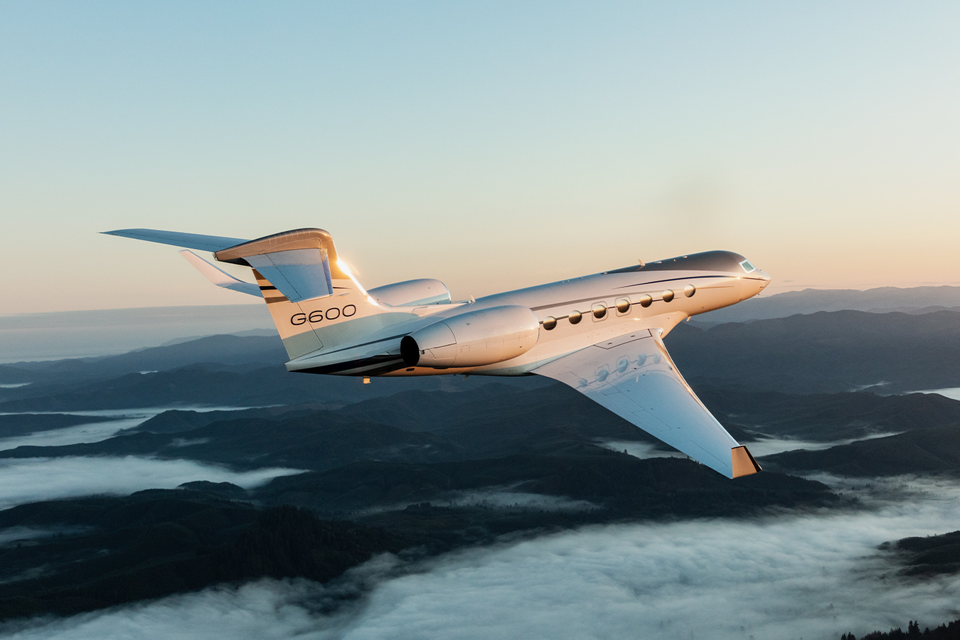 G600 flying over a misty mountainous area