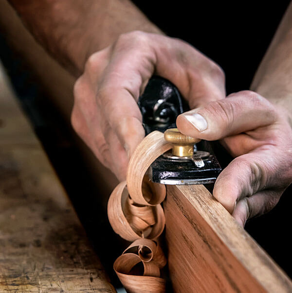 A craftsman carefully smooths wood destined to be part of a Gulfstream aircraft interior.