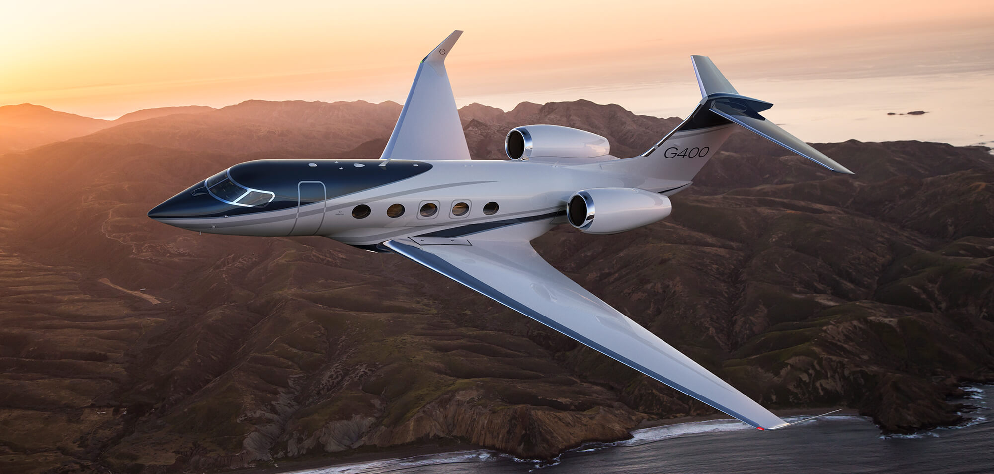 Seen from a above, a Gulfstream G400 flies high above a calm, slate-gray sea.   